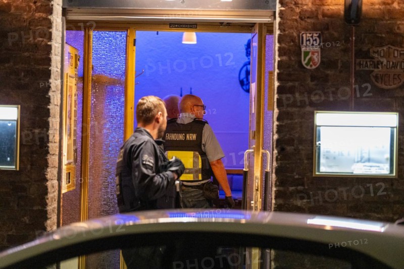 A customs officer enters an illuminated business premises in the evening hours, The Cologne police led a raid against illegal gambling on Friday evening. Around 200 investigators from the police, customs, tax investigation, the public order office, the tax and revenue office, the foreigners authority and the public catering office were out and about on the streets of Cologne on Friday evening. They search 25 properties where there are indications that illegal gambling is taking place. And they make a find