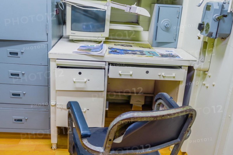 Interior of officer's cabin with desk chair computer and magazines inside battleship on display at Unification Park in Gangneung, South Korea, Asia