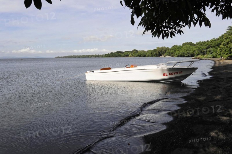 Ometepe Island, Nicaragua, White motorboat on calm shore with cloudy sky in the background, Central America, Central America