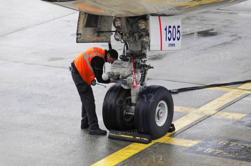 AUGUSTO C. SANDINO Airport, Managua, Nicaragua, An airport employee checks the landing gear of an aircraft at the gate, Central America, Central America