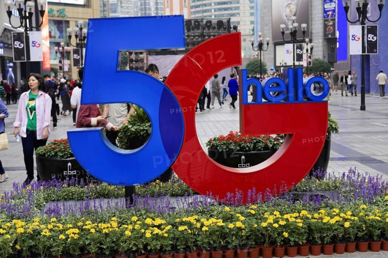 Strolling in Chongqing, Chongqing Province, China, Asia, Advertisement for 5G technology in an urban garden area surrounded by passers-by, Chongqing, Asia