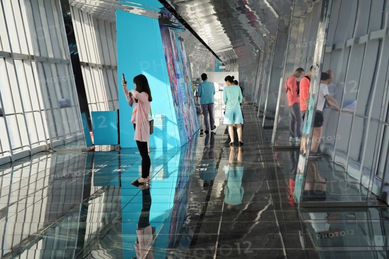 Viewing terrace, The Bottle Opener at 492 metres, visitors in front of a blue exhibition wall on a reflective viewing platform, Shanghai, China, Asia