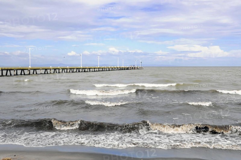 Granada, Nicaragua, Calm waves of Lake Nicaragua meet a long pier under a cloudy sky, Central America, Central America