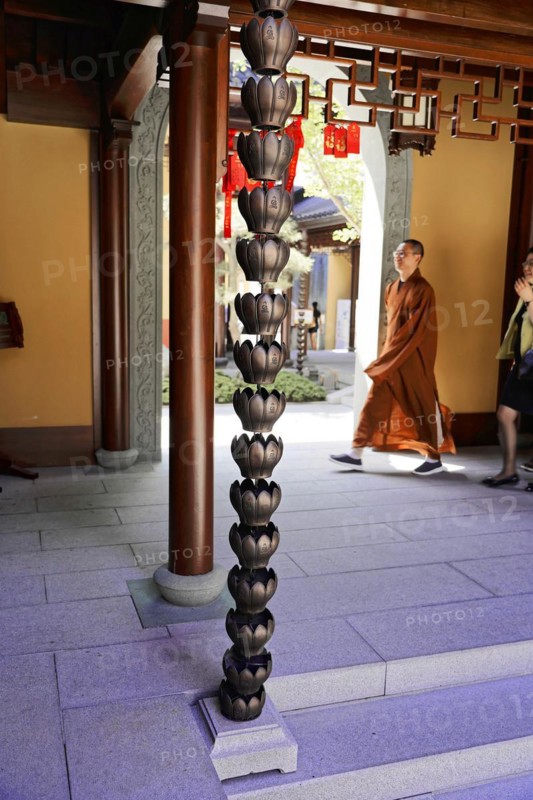 Jade Buddha Temple, Shanghai, Monk walking past ornate temple pillars and traditional carvings, Shanghai, China, Asia