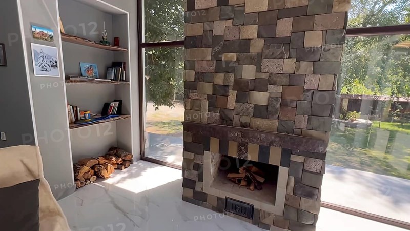 Interior of a modern house, fireplace made of stone and wood