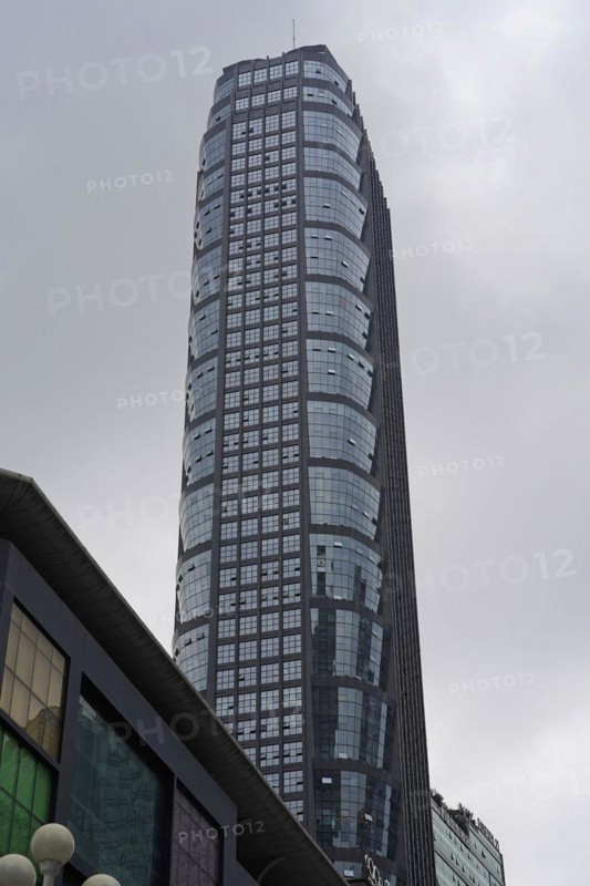 Chongqing, Chongqing Province, China, Asia, A large skyscraper with a glass facade towers into the cloudy sky, Asia