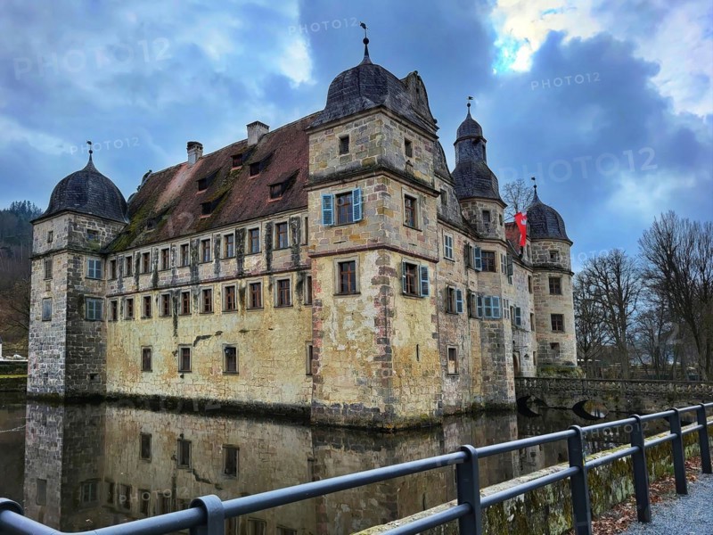 Mitwitz moated castle under a cloudy sky. Mitwitz, Kronach, Upper Franconia, Bavaria, Germany, Europe