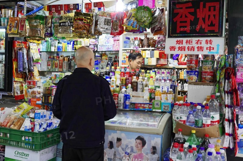 Strolling in Chongqing, Chongqing Province, China, Asia, A customer looks at a selection of food and beverages in a shop, Chongqing, Asia