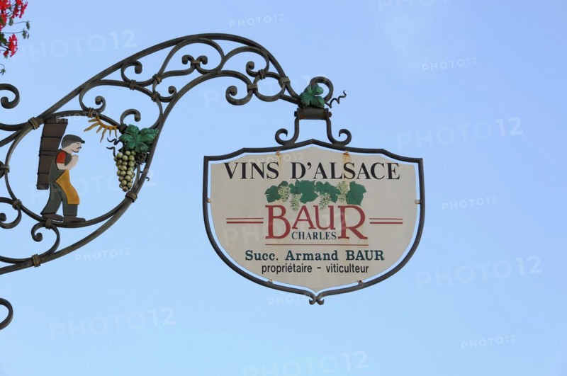 Eguisheim, Alsace, France, Europe, A metal wine sign with the inscription 'VINS D'ALSACE BAUR' in front of a blue sky, Europe