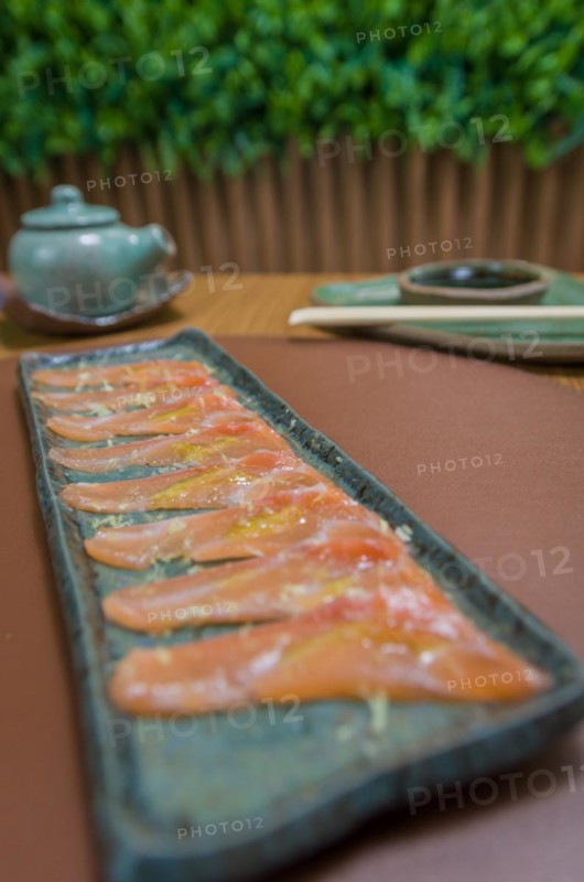 Delicious premium salmon sashimi arranged on an elegant handmade platter