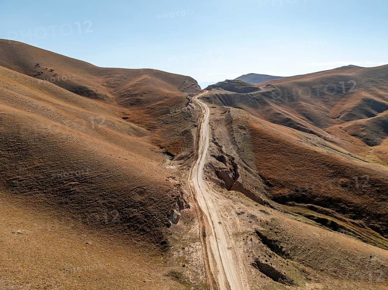 Moldo-Ashuu Pass, rutted road between yellow hills, near Baetov, Naryn region, Kyrgyzstan, Asia