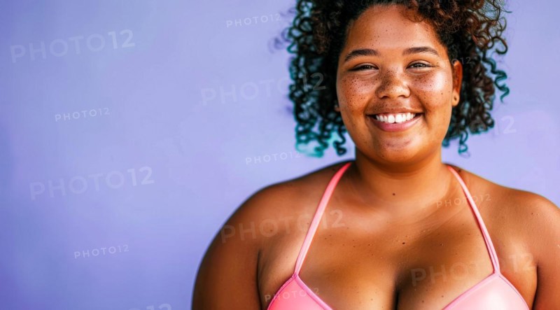A plus size black afro-american bikini model with curly hair is smiling and wearing a bikini top. Concept of confidence and happiness, AI generated