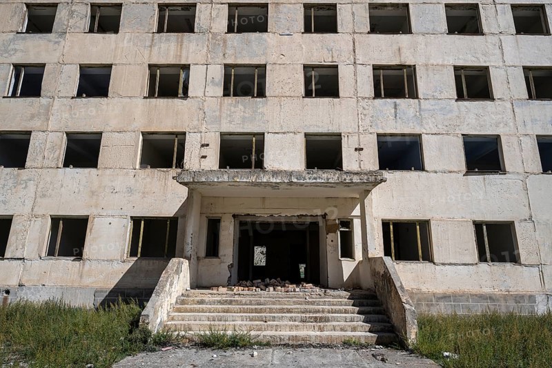 Entrance to an abandoned ruined residential building, old Soviet apartment block in the ghost town, Engilchek, Tian Shan, Kyrgyzstan, Asia