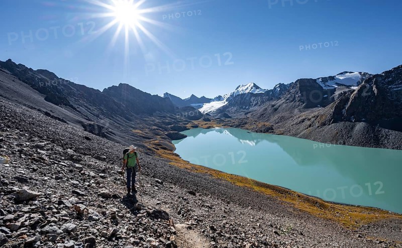 Mountaineers on the way to the Ala Kul Pass, turquoise Ala Kul mountain lake in the morning light, Sun Star, Tien Shan Mountains, Kyrgyzstan, Asia