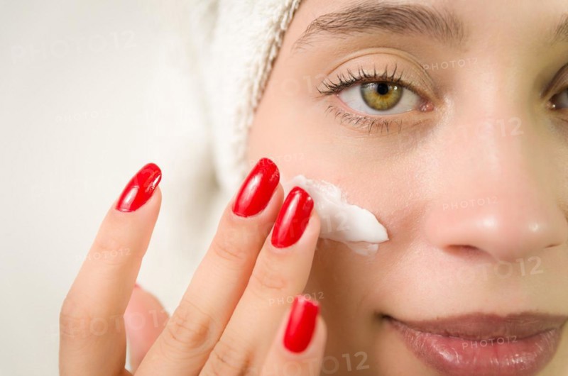 Hydration. Cream smear. Beuaty close up portrait of young woman with a healthy glowing skin is applying a skincare product