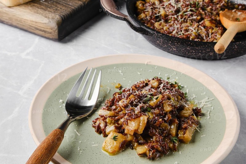 Risotto with pink rice, pear and blue cheese served on a table