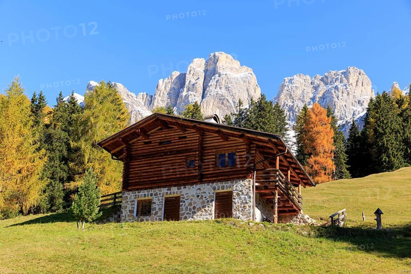 Rustic alpine hut against a backdrop of rugged mountains in autumn, Italy, Alto Adige, Bolzano province, Dolomites, rose garden, Europe