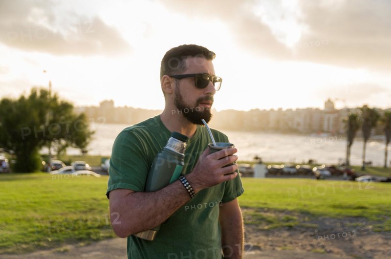Man drinking chimarrao, mate tea tea (an infusion of yerba mate tea tea with hot water) at sunset in uruguay