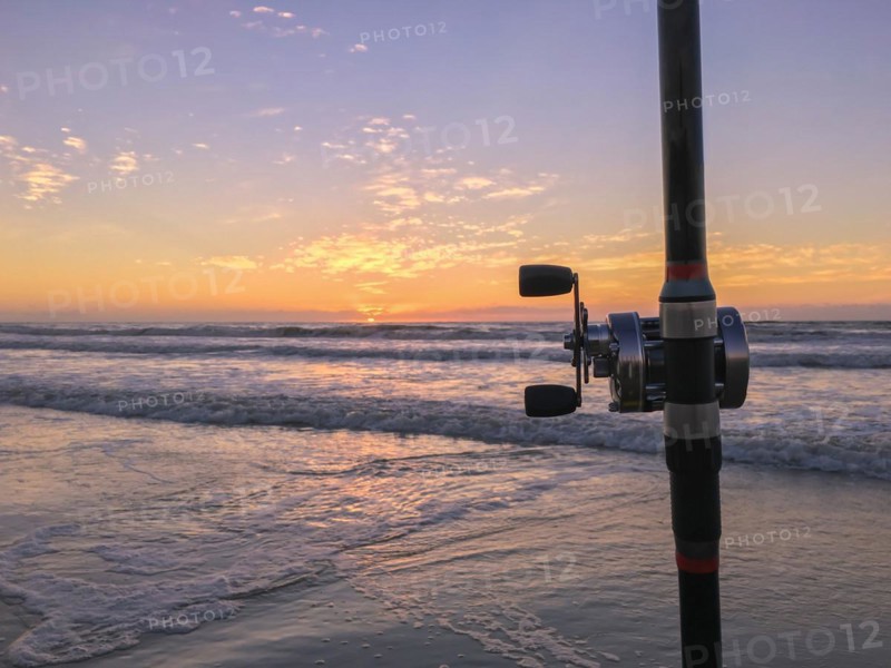 Fishing rod on beach at sunset, surfing cast