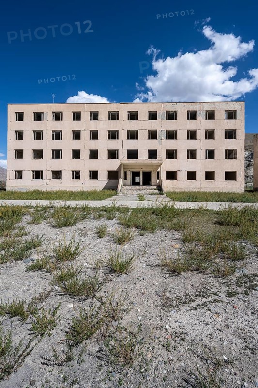 Abandoned destroyed residential building, old Soviet block of flats in the ghost town, Engilchek, Tian Shan, Kyrgyzstan, Asia