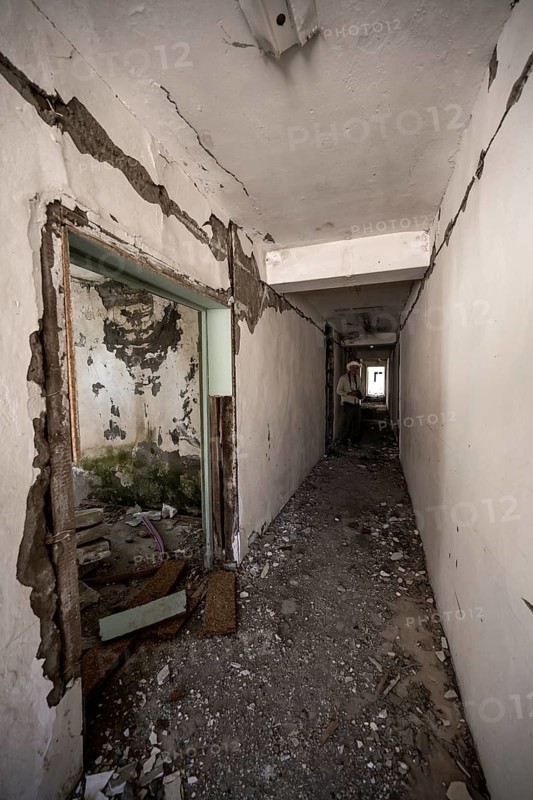 Tourist with camera in an abandoned ruined corridor, ghost town, Engilchek, Tian Shan, Kyrgyzstan, Asia