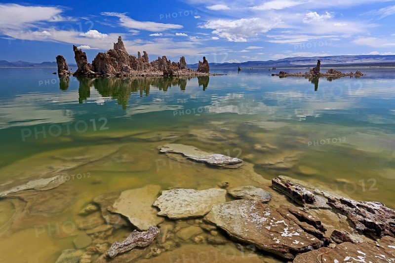 Limestone tufa structures protrude into a lake with clear water and a cloudy sky, Mono Lake, North America, USA, South-West, California, California, North America