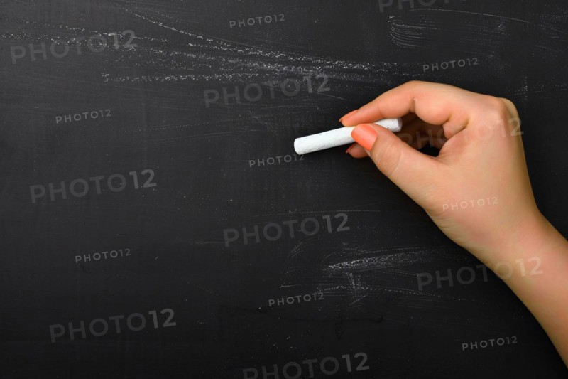 Woman's hand writing on chalkboard with piece of white chalk. KI generiert, generiert, AI generated