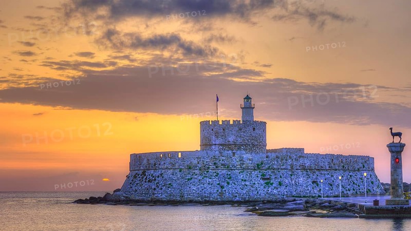 The fortress near the coast under a sky with sunset colours, sunrise, dawn, lighthouse, European roe deer statue, Fort of Saint Nikolaos, harbour promenade, Rhodes, Dodecanese, Greek Islands, Greece, Europe