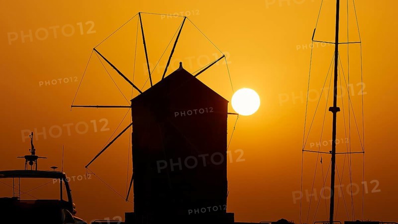 Silhouette of a windmill in front of the rising sun with a warm colour gradient, twilight, Mandraki Oat, Rhodes, Dodecanese, Greek Islands, Greece, Europe