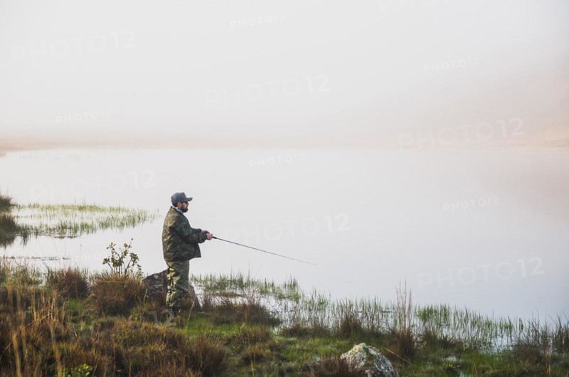 Sport fisherman fishing in lake on cloudy day, Cambara do sul, Rio Grande do sul, Brazil, South America