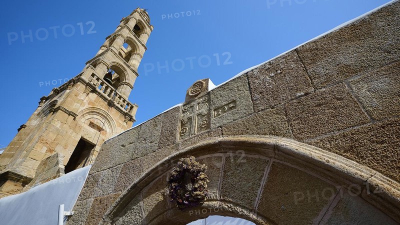 Stone arch in front of a historic church tower under a bright blue sky, Panagia Church, St Mary's Church, Lindos village, Rhodes, Dodecanese, Greek Islands, Greece, Europe