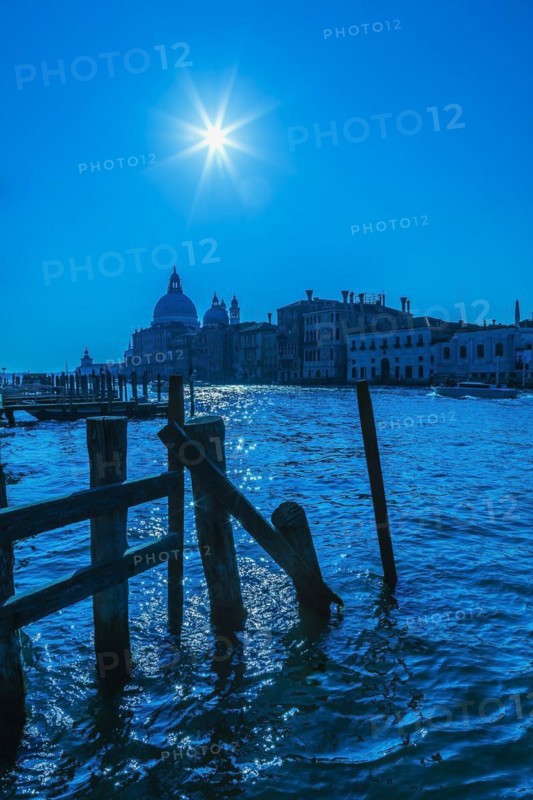 Silhouetted view of Grand canal with water taxis, Santa Maria della Salute basilica and Renaissance architectural style palace buildings in Dorsoduro, Venice, Veneto, Italy, Europe