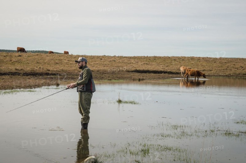 Sport fisherman fishing in lake on cloudy day, Cambara do sul, Rio Grande do sul, Brazil, South America