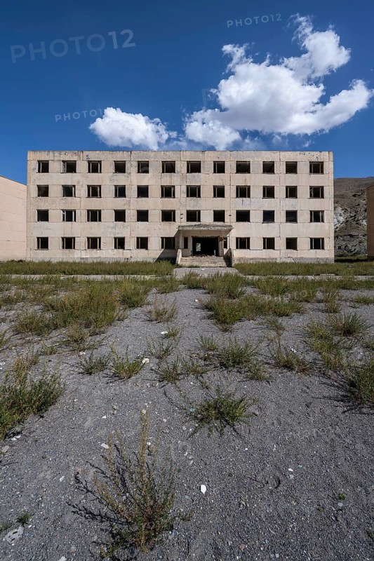 Abandoned destroyed residential building, old Soviet block of flats in the ghost town, Engilchek, Tian Shan, Kyrgyzstan, Asia