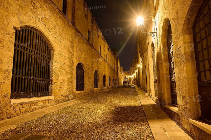 An old cobbled street at night, illuminated by street lamps creating a warm atmosphere, Knights Street, night shot, Rhodes Old Town, Rhodes Town, Rhodes, Dodecanese, Greek Islands, Greece, Europe
