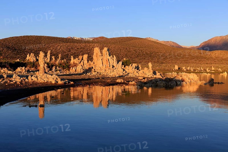 Warm sunset light on tufa towers at Mono Lake with calm water reflection, Mono Lake, North America, USA, South-West, California, California, North America