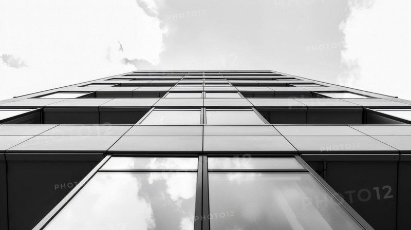 Greyscale image of a skyscraper's glass facade with a cloud reflected in it, AI generated