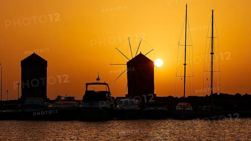 Harbour view with windmills and boat silhouettes at a bright sunrise, twilight, Mandraki Harbour, Rhodes, Dodecanese, Greek Islands, Greece, Europe