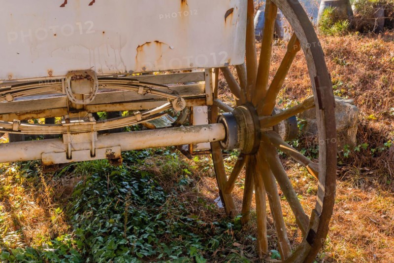 Rear undercarriage and wooden wheel on old rusted horse drawn carriage in South Korea