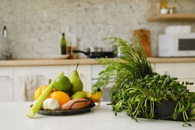Fresh vegetables, herbs and fruits on a kitchen table