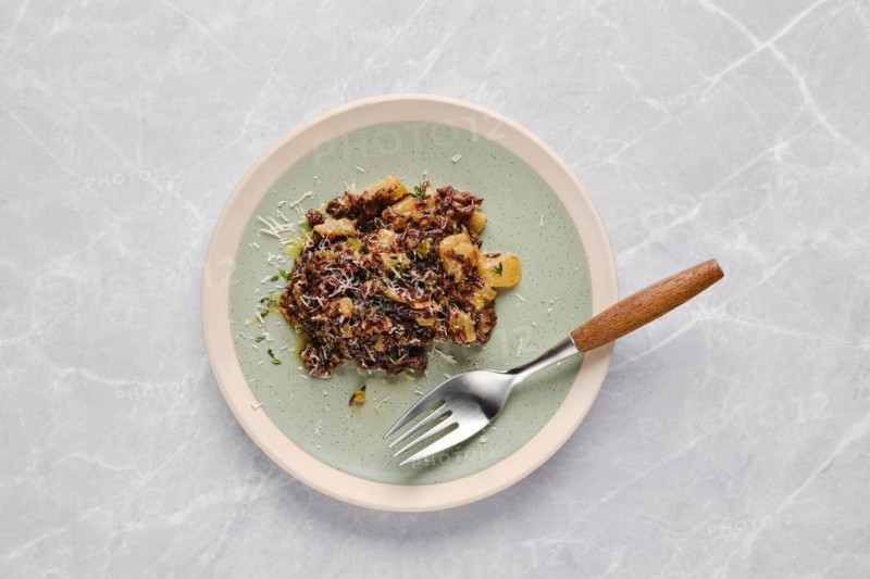 Plate with risotto with pink rice, pear and blue cheese on a table