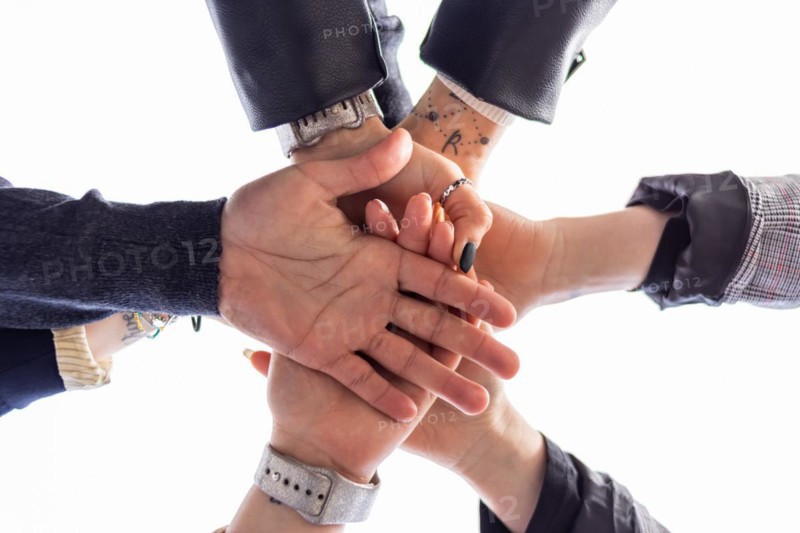 Low angle of group of people bumping fists. Togetherness and togetherness concept