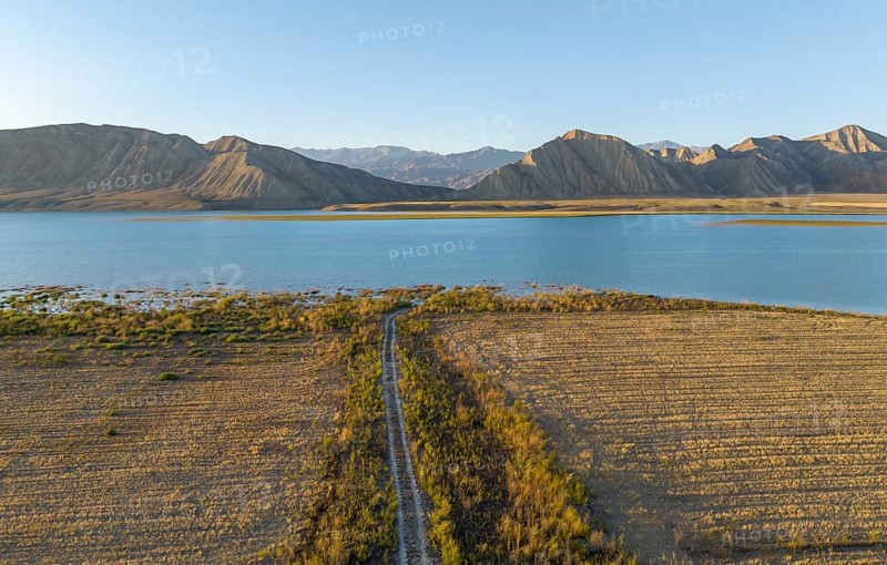 Dirt road leads between fields to the lake, Toktogul reservoir, aerial view, Toktogul, Kyrgyzstan, Asia