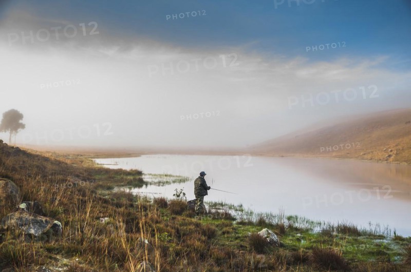 Sport fisherman fishing in lake on cloudy day, Cambara do sul, Rio Grande do sul, Brazil, South America