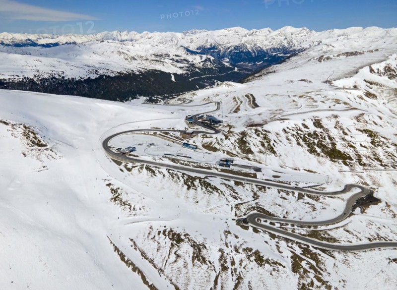 Mountain road winds through a wintry landscape in daylight, serpentine road near El Pas de la Casa, Encamp, Andorra, Pyrenees, Europe