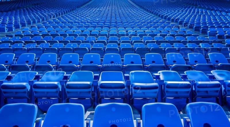 Big empty stadium full of blue seats, AI generated