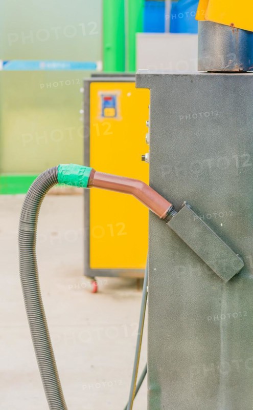Brown vacuum cleaner handle with hose attached with green duct tape at gas station car wash in South Korea