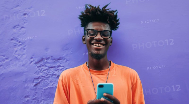 Black young positive man with dreadlocks is smiling and standing in front of the building wall. Concept of confidence and positivity, AI generated