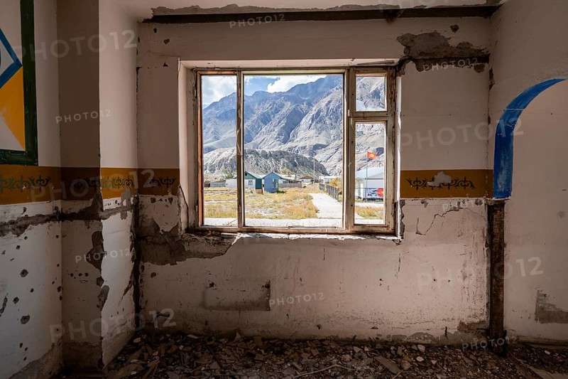 View through a window onto the mountain landscape, abandoned destroyed room with colourful wall painting, ghost town, Engilchek, Tian Shan, Kyrgyzstan, Asia