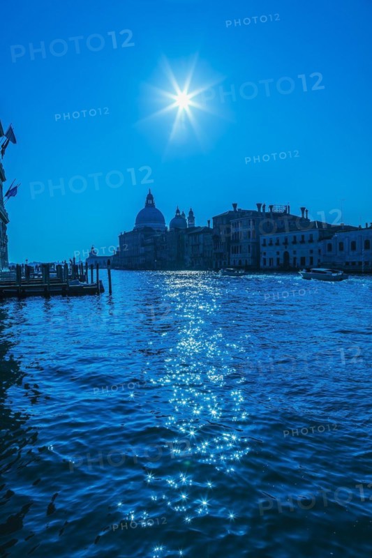 Silhouetted view of Grand canal with water taxis, Santa Maria della Salute basilica and Renaissance architectural style palace buildings in Dorsoduro, Venice, Veneto, Italy, Europe